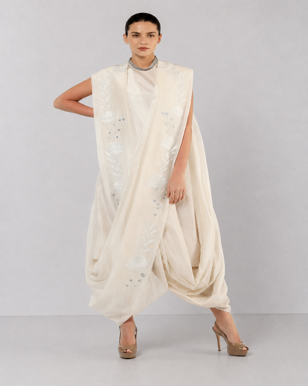 Ivory embroidered draped ensemble featuring floral threadwork, a fluid cowl silhouette, and contemporary cape-inspired styling.