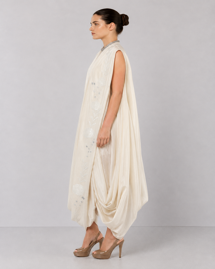 Ivory embroidered draped ensemble featuring floral threadwork, a fluid cowl silhouette, and contemporary cape-inspired styling