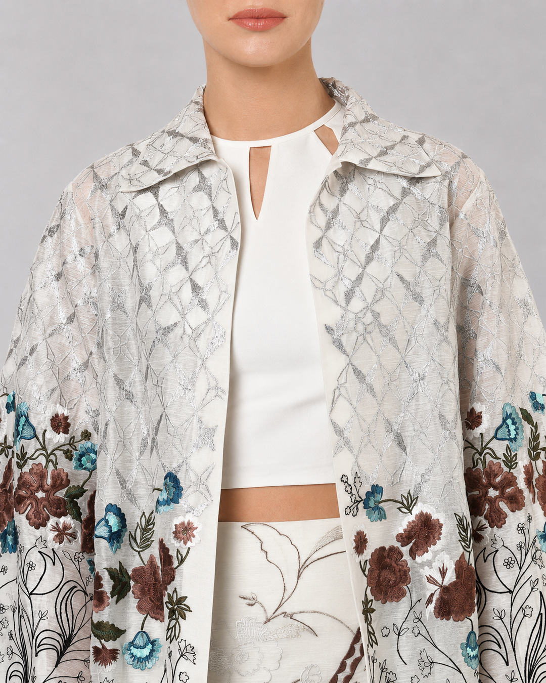 Ivory Long Jacket Paired With Crop Top &amp; Skirt Featuring Trench Overlay With Botanical Artwork.