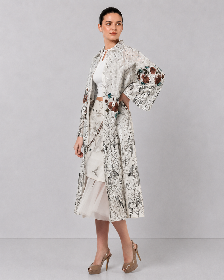 Ivory Long Jacket Paired With Crop Top &amp; Skirt Featuring Trench Overlay With Botanical Artwork.