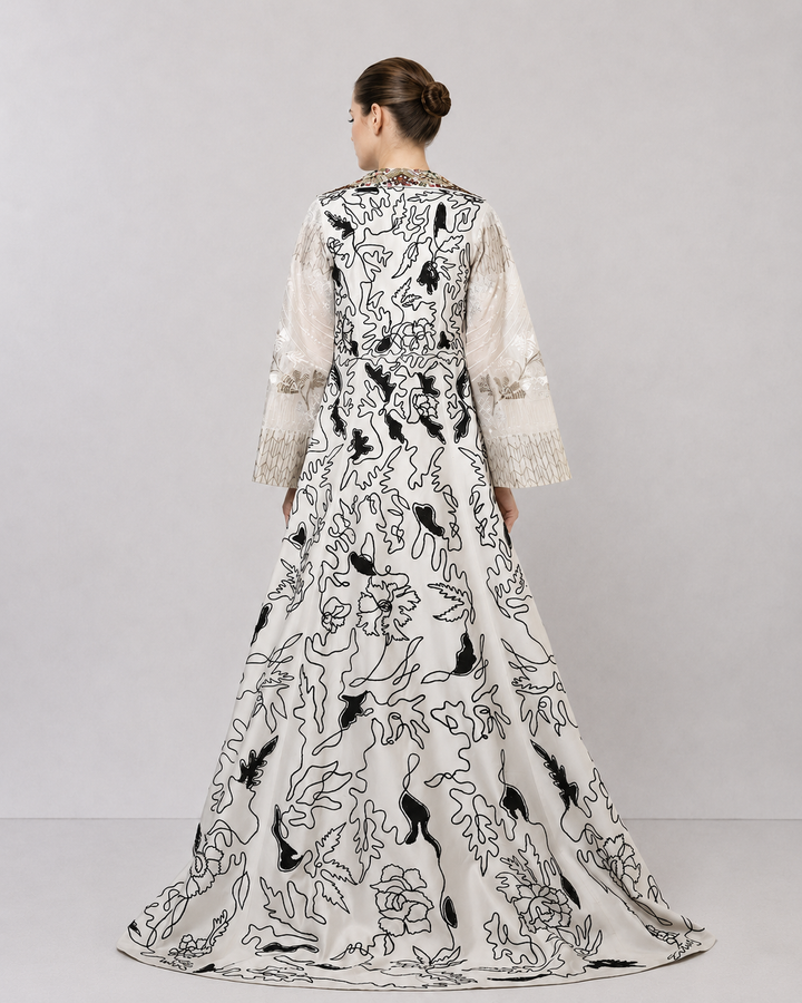 Ivory layered dress with embroidered artwork and statement overcoat.