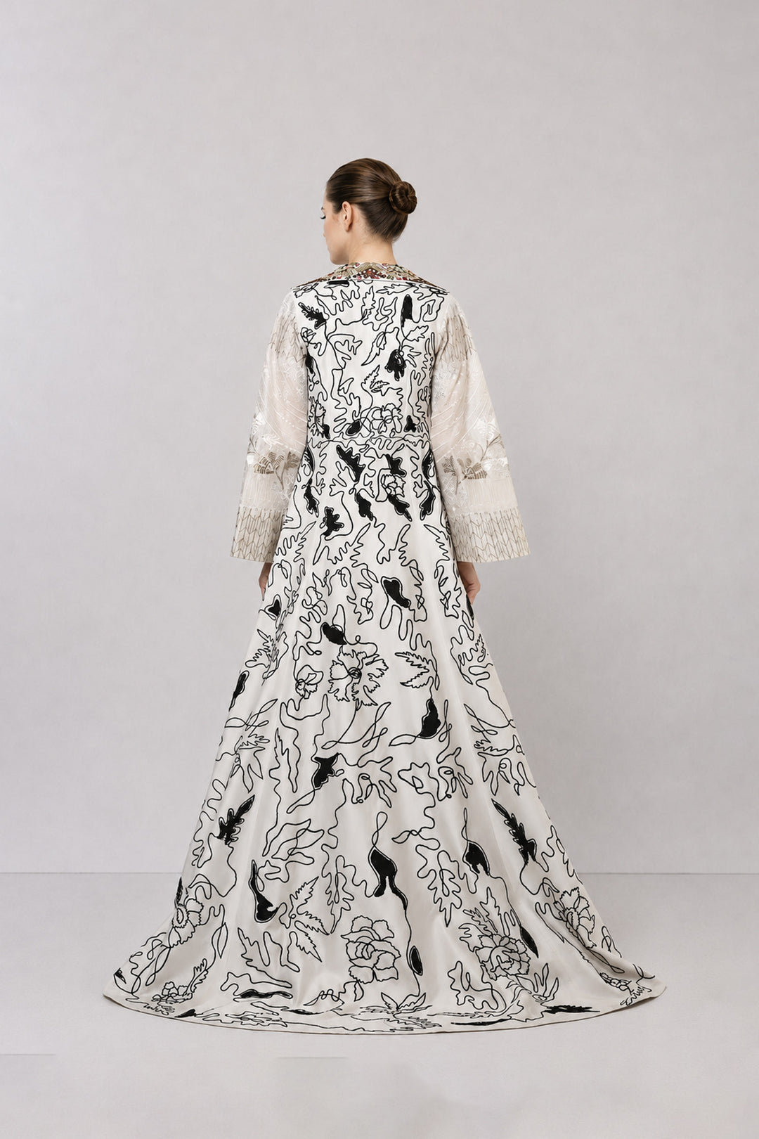 Ivory layered dress with embroidered artwork and statement overcoat.