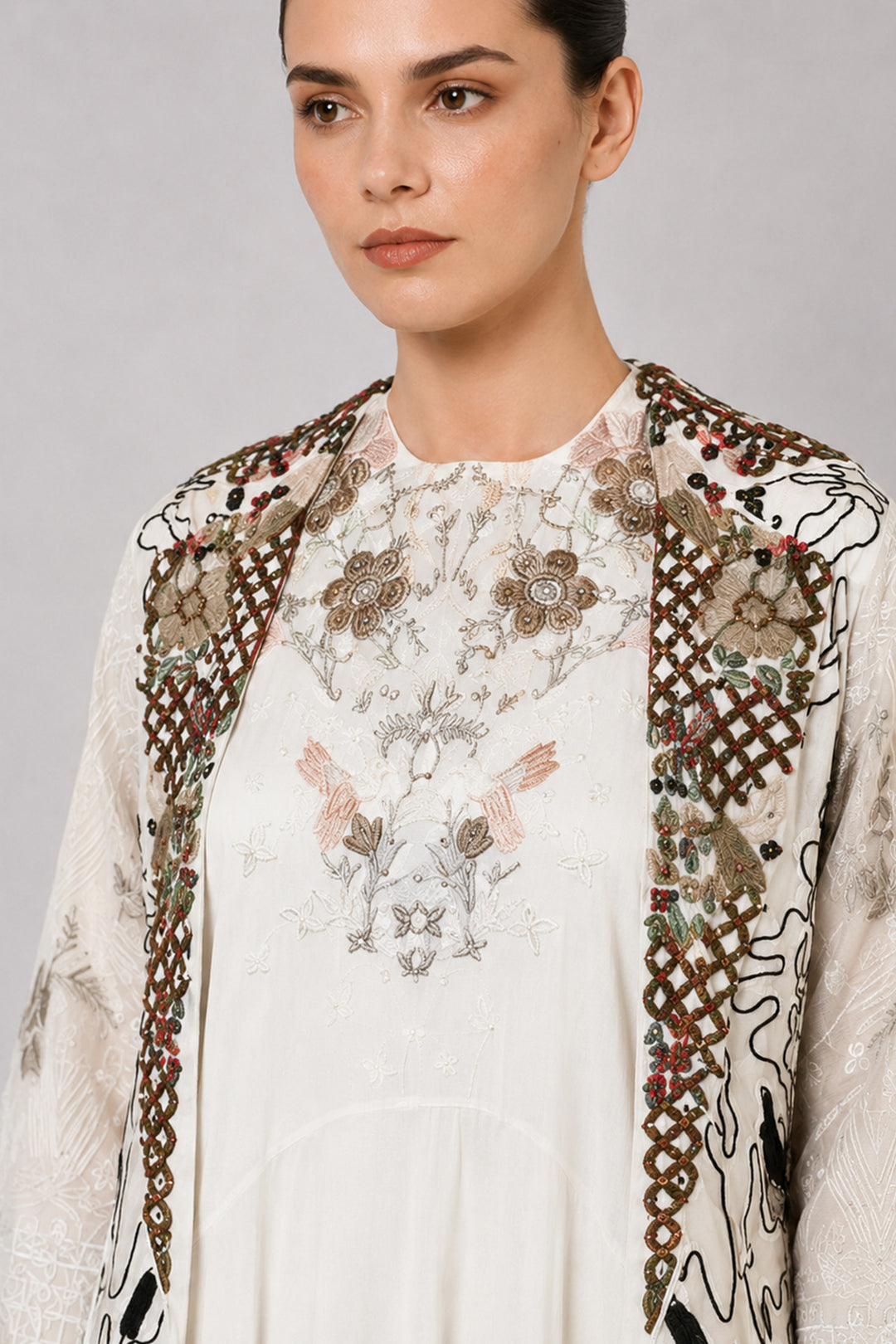 Ivory layered dress with embroidered artwork and statement overcoat.