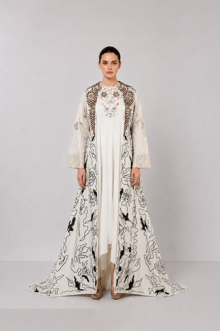 Ivory layered dress with embroidered artwork and statement overcoat.