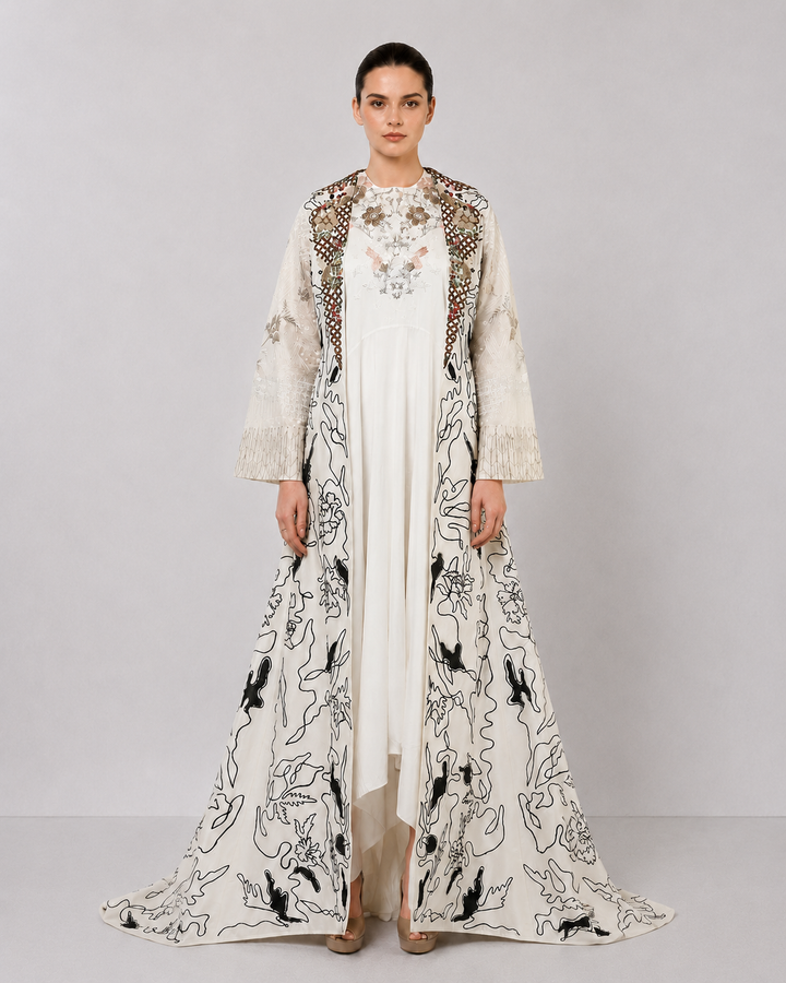 Ivory layered dress with embroidered artwork and statement overcoat.