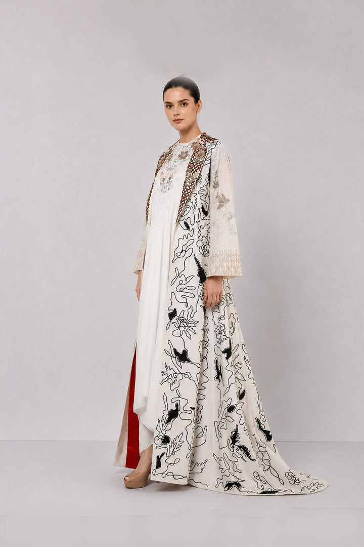 Ivory layered dress with embroidered artwork and statement overcoat.