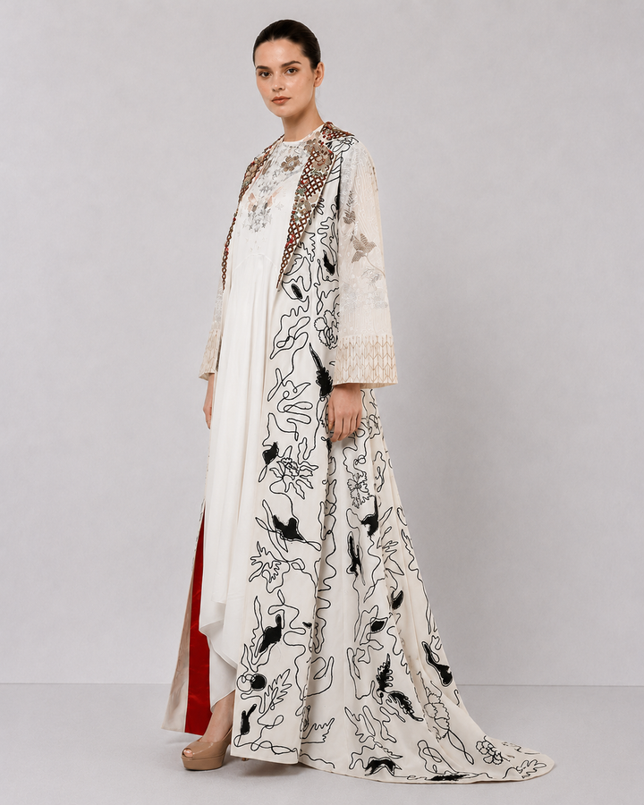 Ivory layered dress with embroidered artwork and statement overcoat.