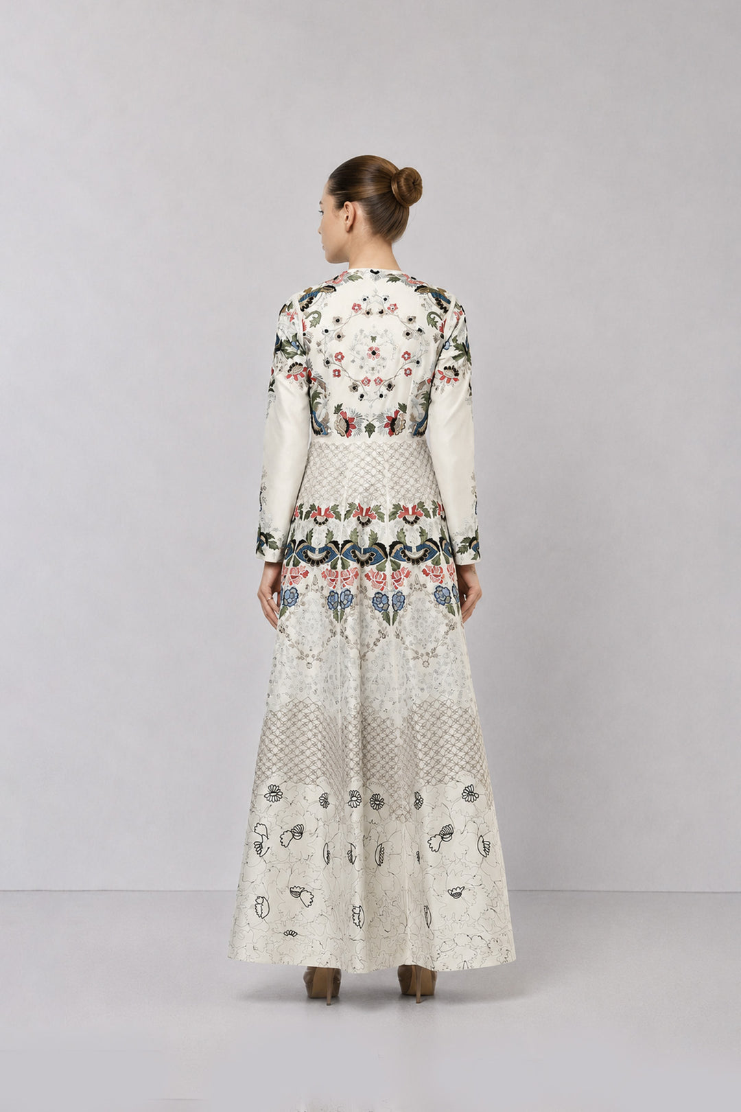 Ivory embroidered gown with artisanal floral motifs and flared silhouette.