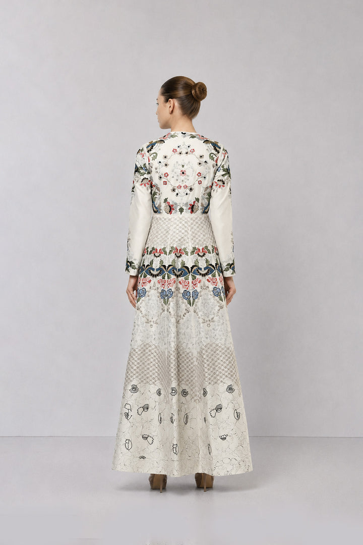 Ivory embroidered gown with artisanal floral motifs and flared silhouette.