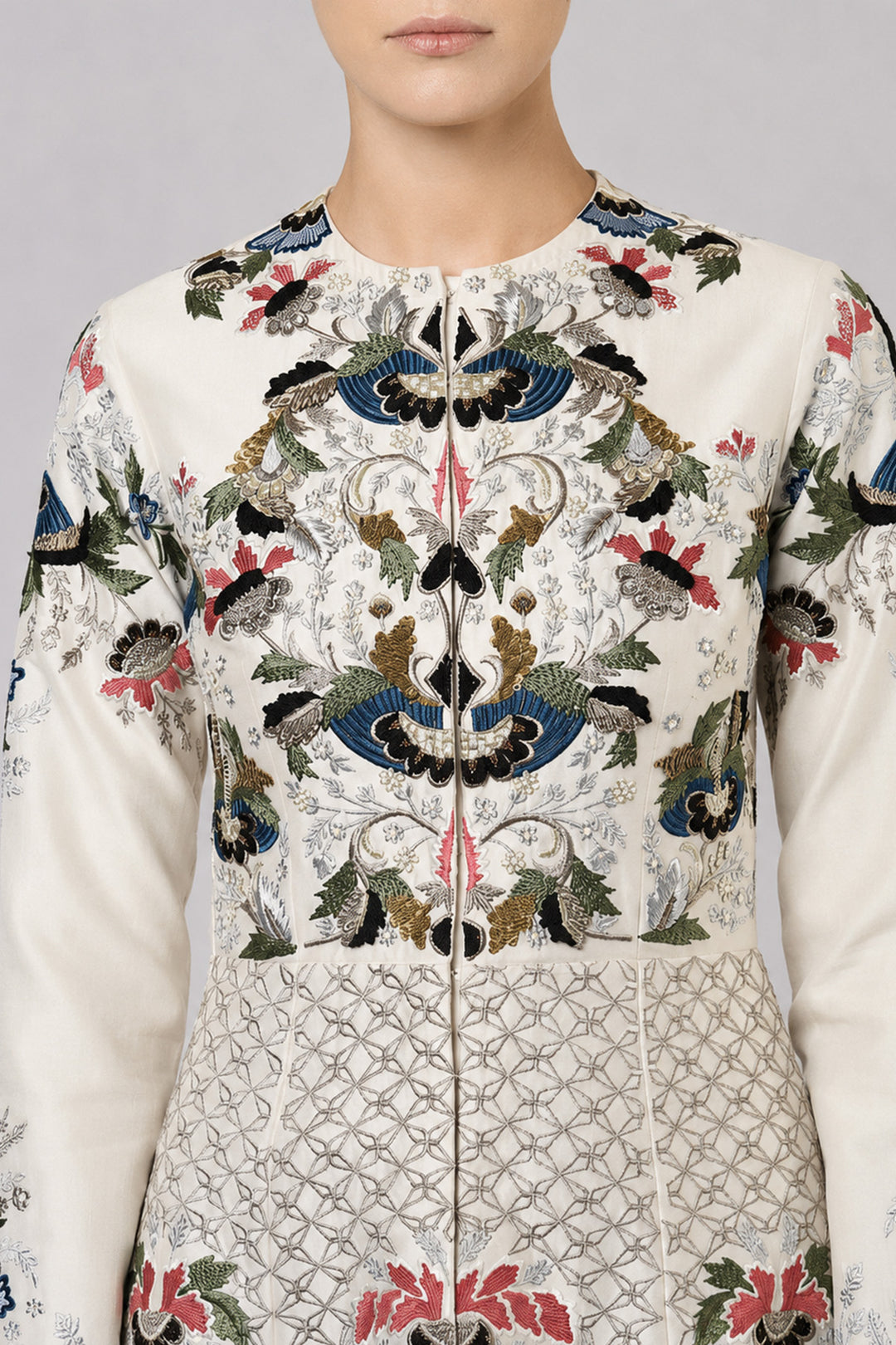 Ivory embroidered gown with artisanal floral motifs and flared silhouette.