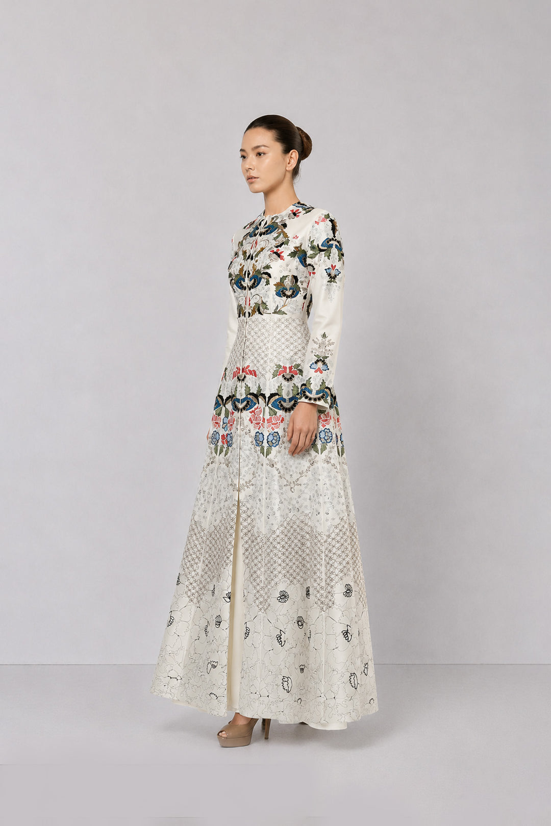 Ivory embroidered gown with artisanal floral motifs and flared silhouette.