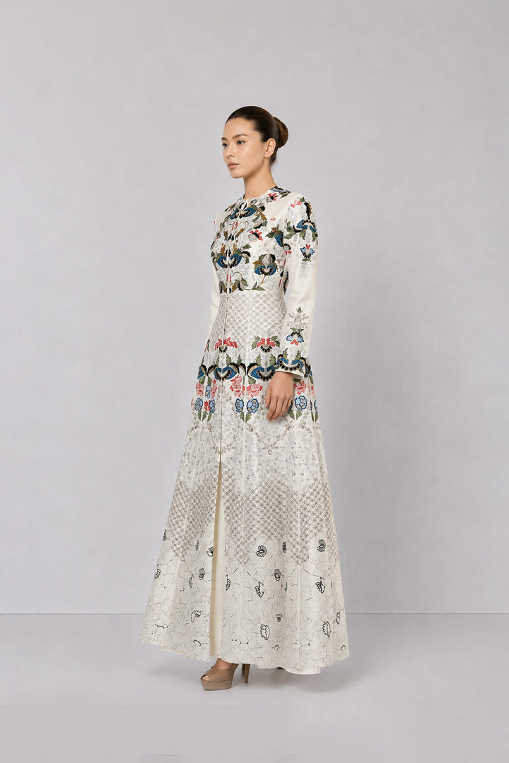 Ivory embroidered gown with artisanal floral motifs and flared silhouette.