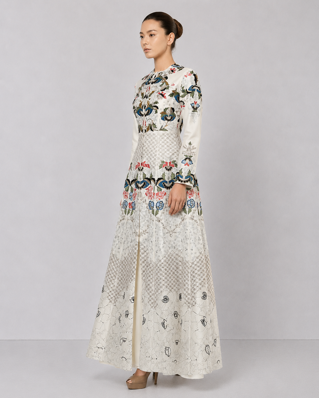 Ivory embroidered gown with artisanal floral motifs and flared silhouette.