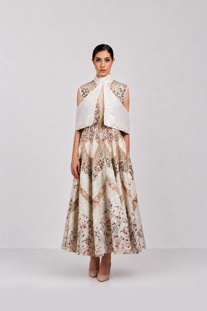 Ivory embroidered dress with sculpted cape collar and botanical motifs.