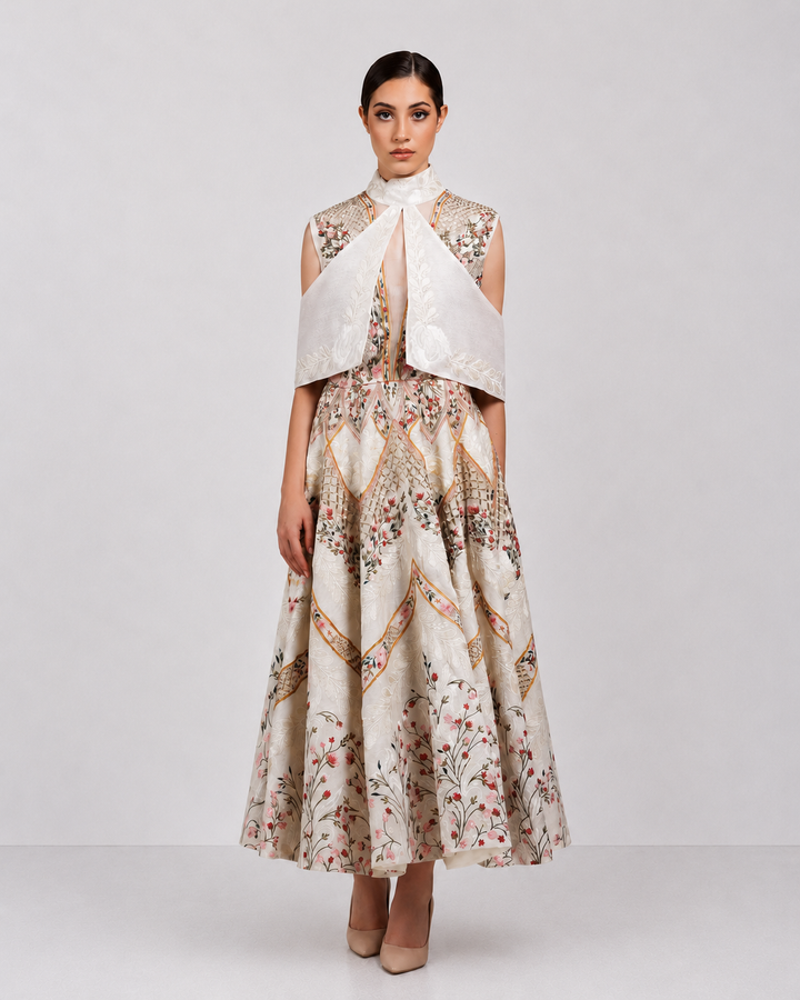 Ivory embroidered dress with sculpted cape collar and botanical motifs.