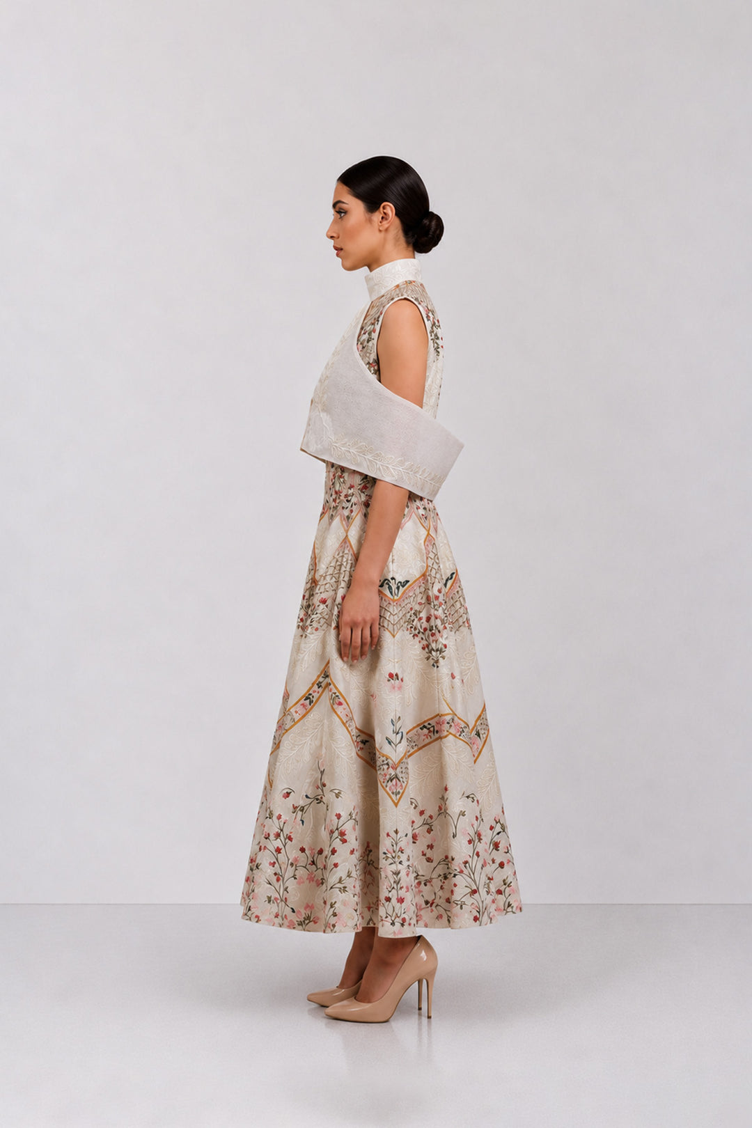Ivory embroidered dress with sculpted cape collar and botanical motifs.