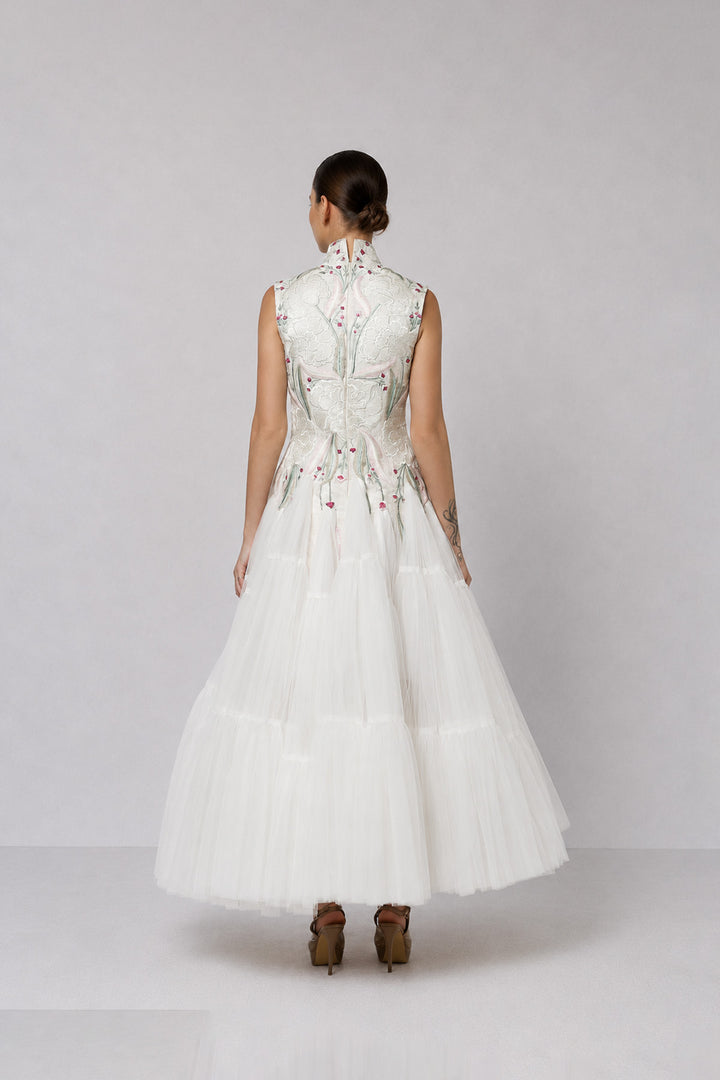 Ivory tiered tulle gown with embroidered bodice and high-neck detailing.