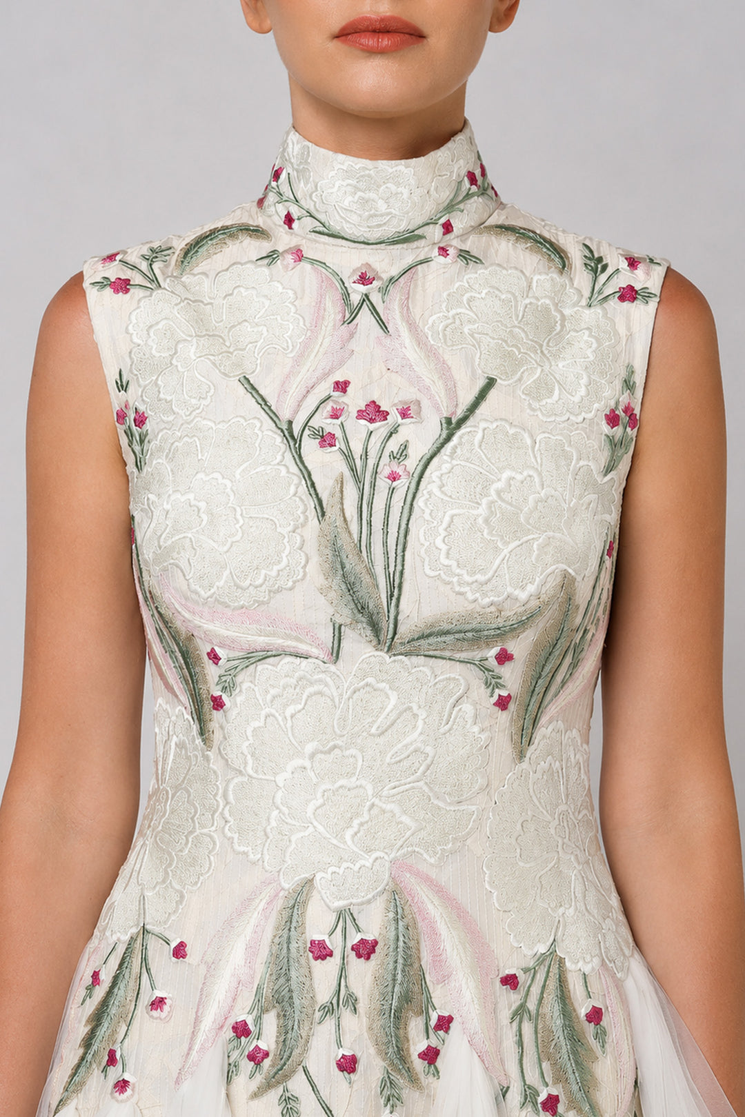 Ivory tiered tulle gown with embroidered bodice and high-neck detailing.