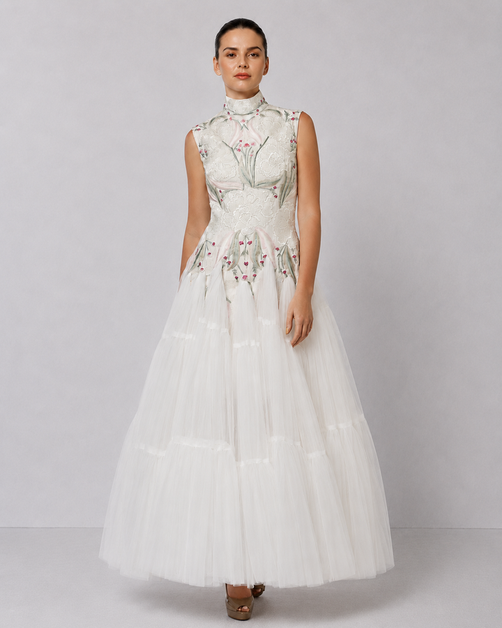 Ivory tiered tulle gown with embroidered bodice and high-neck detailing.