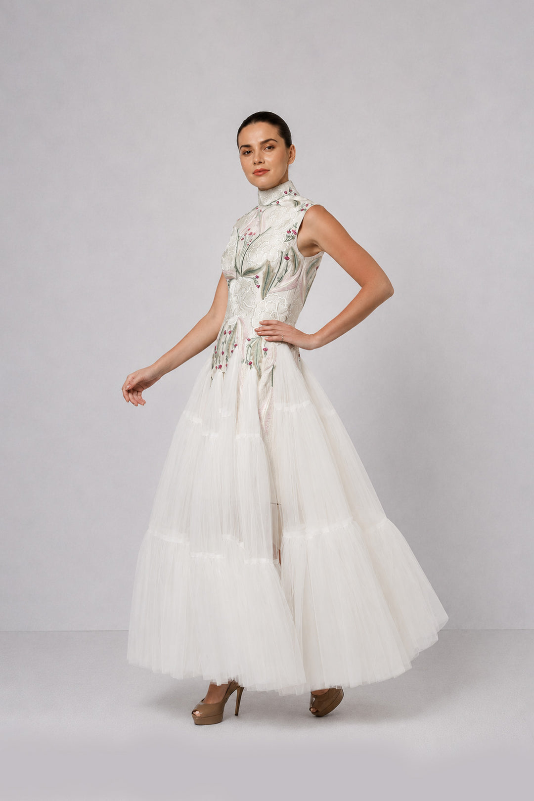 Ivory tiered tulle gown with embroidered bodice and high-neck detailing.