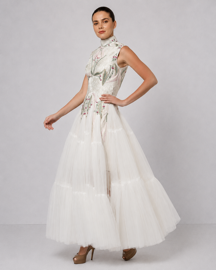 Ivory tiered tulle gown with embroidered bodice and high-neck detailing.