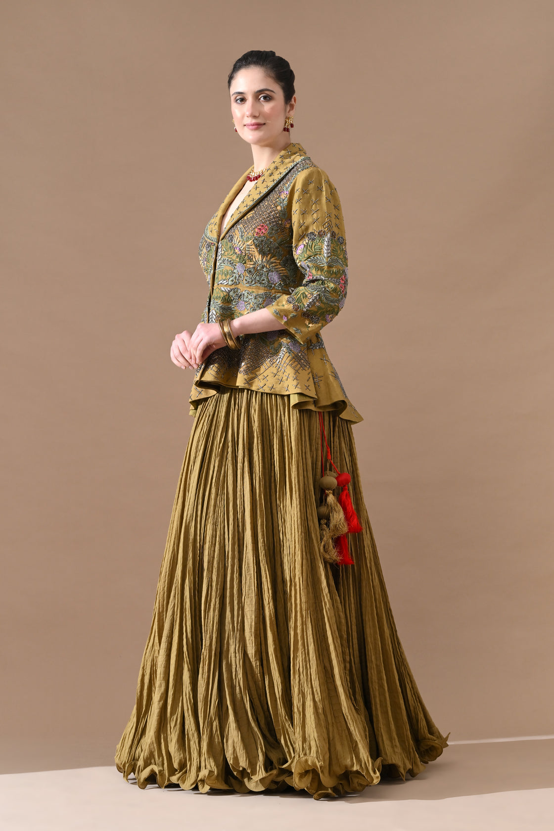 A olive green jacket features intricate all-over embroidery with skirt