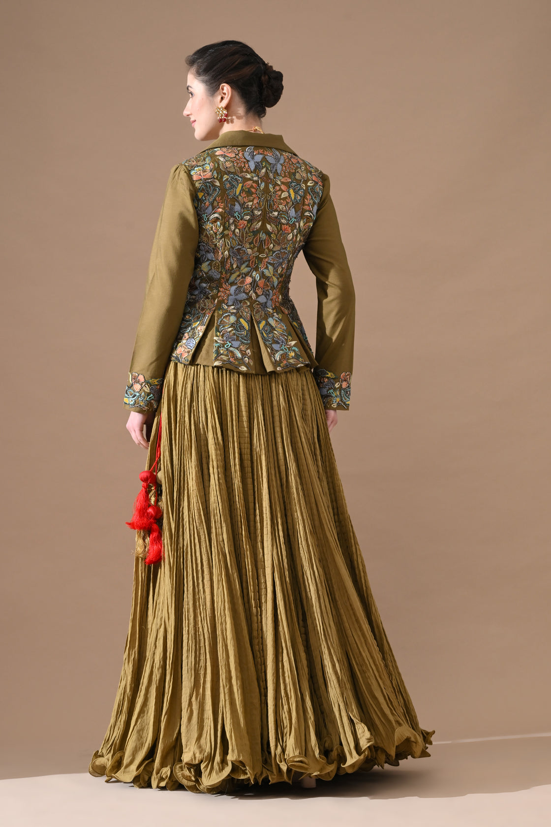 A olive green jacket features intricate all-over embroidery with skirt