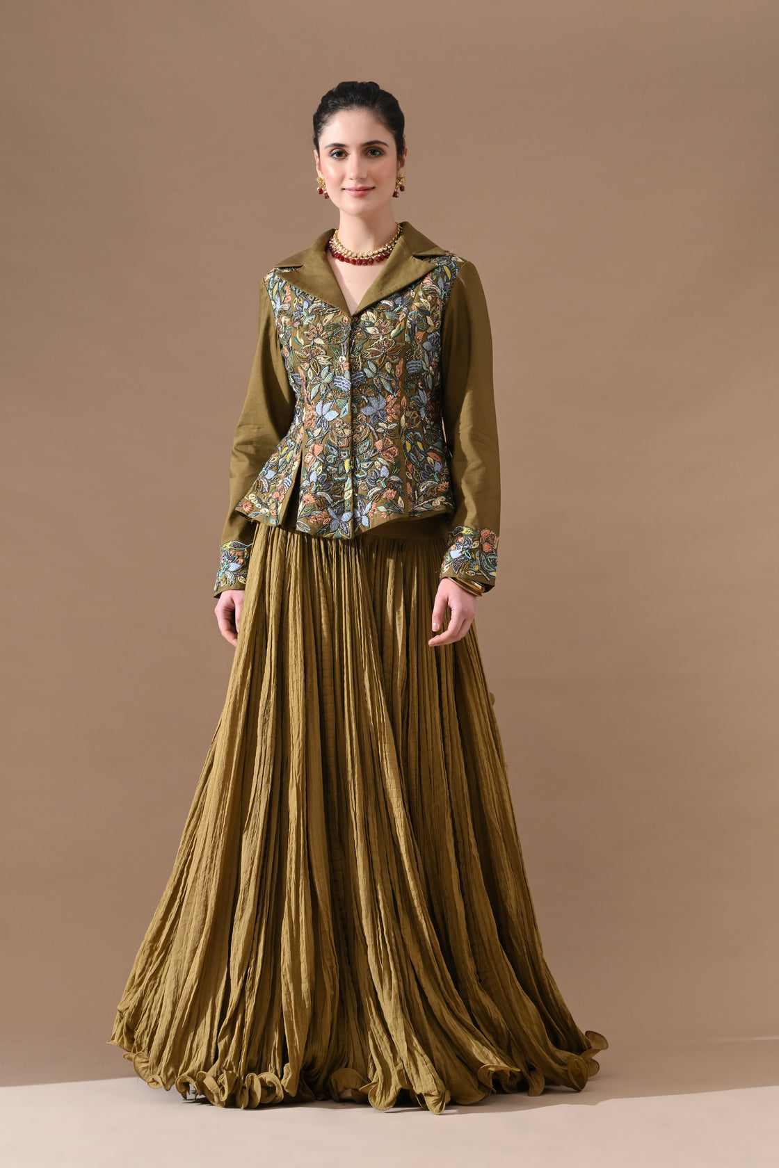 A olive green jacket features intricate all-over embroidery with skirt