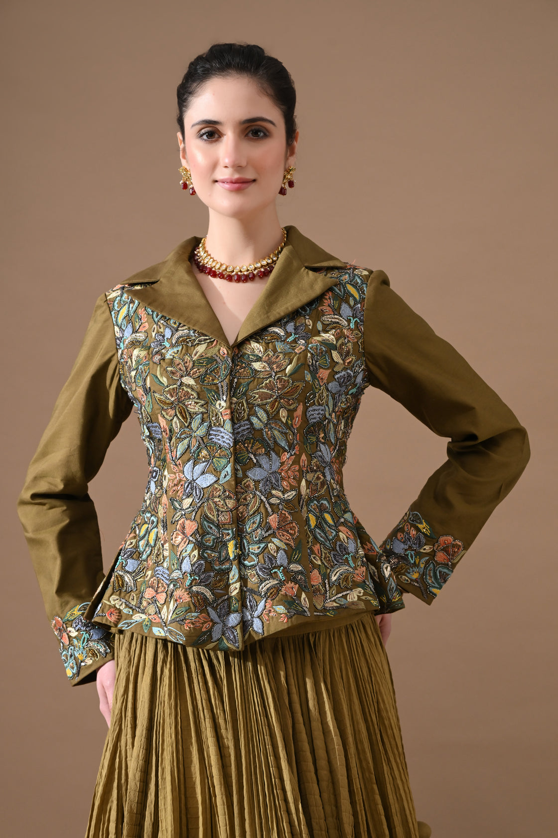 A olive green jacket features intricate all-over embroidery with skirt
