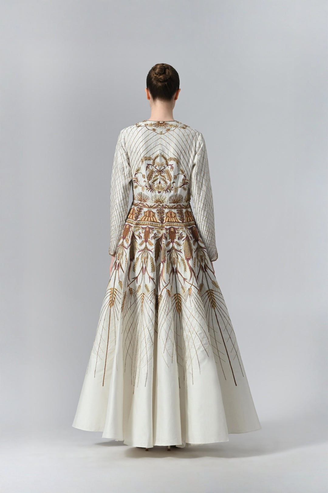 Ivory embroidered A-line gown featuring elegant round neckline, full-sleeves, structured bodice, and the gown is adorned with intricate botanical &amp; heritage-inspired motifs.