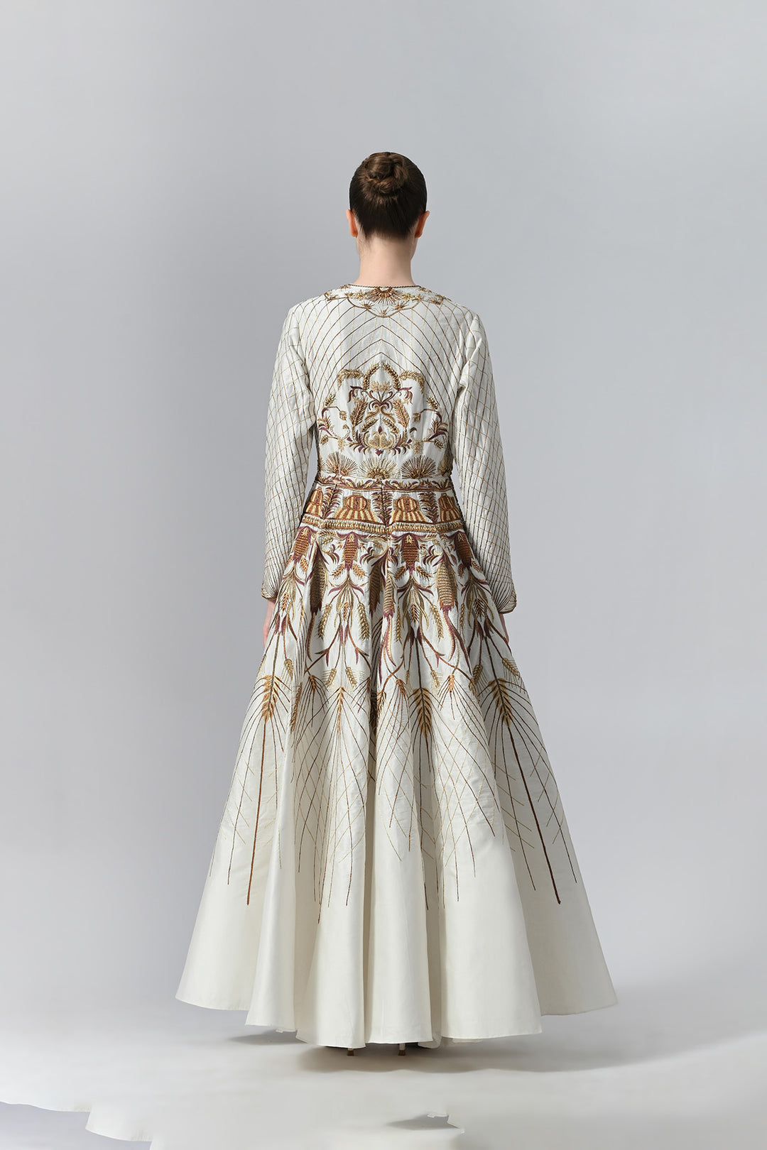Ivory embroidered A-line gown featuring elegant round neckline, full-sleeves, structured bodice, and the gown is adorned with intricate botanical &amp; heritage-inspired motifs.