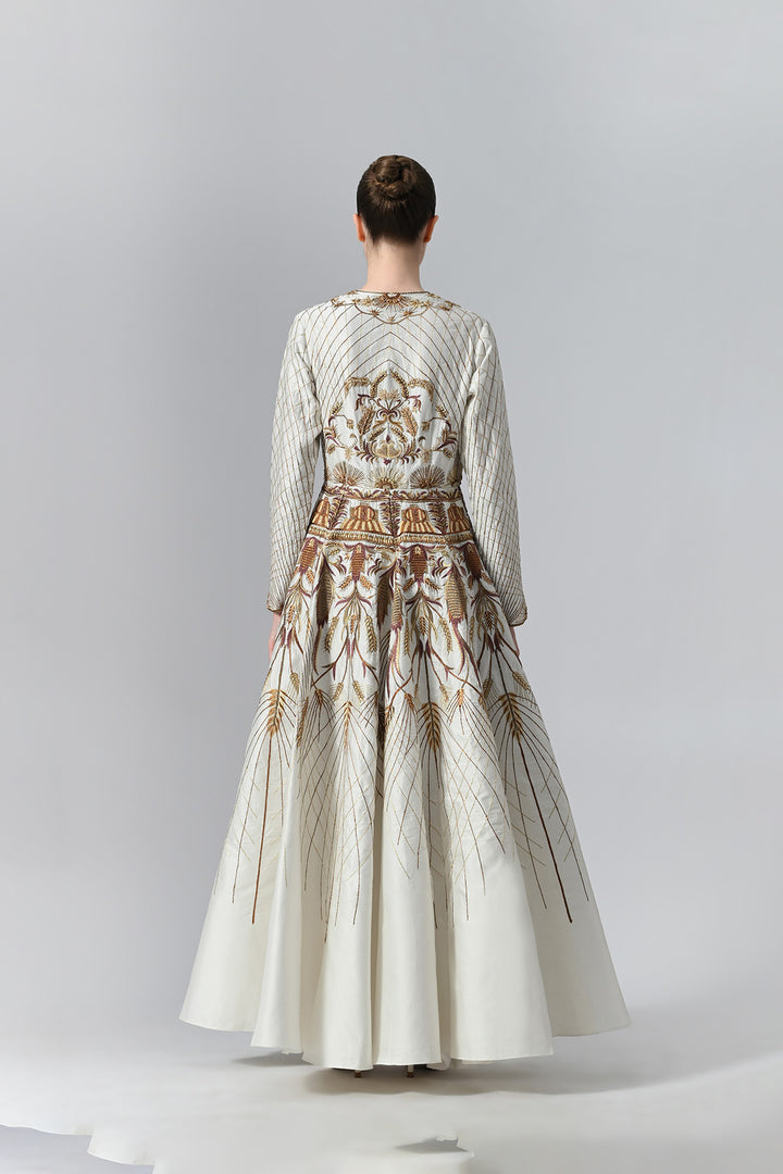 Ivory embroidered A-line gown featuring elegant round neckline, full-sleeves, structured bodice, and the gown is adorned with intricate botanical &amp; heritage-inspired motifs.