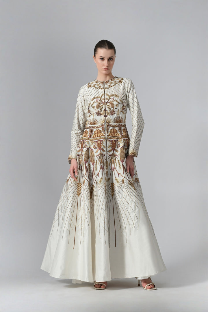 Ivory embroidered A-line gown featuring elegant round neckline, full-sleeves, structured bodice, and the gown is adorned with intricate botanical &amp; heritage-inspired motifs.