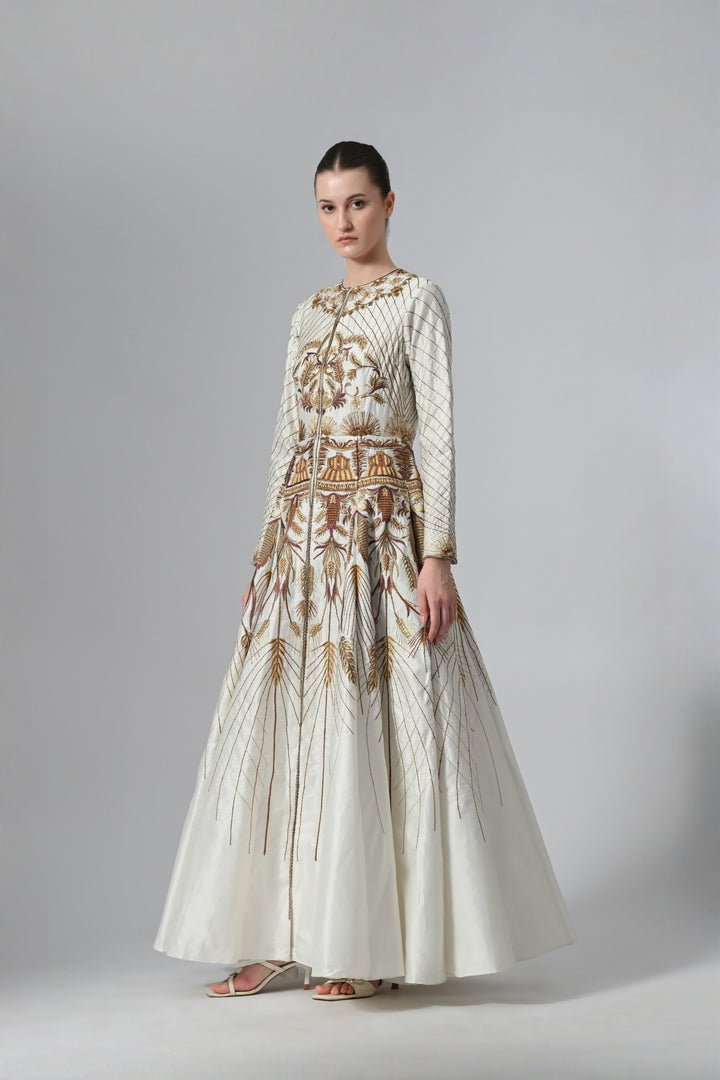 Ivory embroidered A-line gown featuring elegant round neckline, full-sleeves, structured bodice, and the gown is adorned with intricate botanical &amp; heritage-inspired motifs.