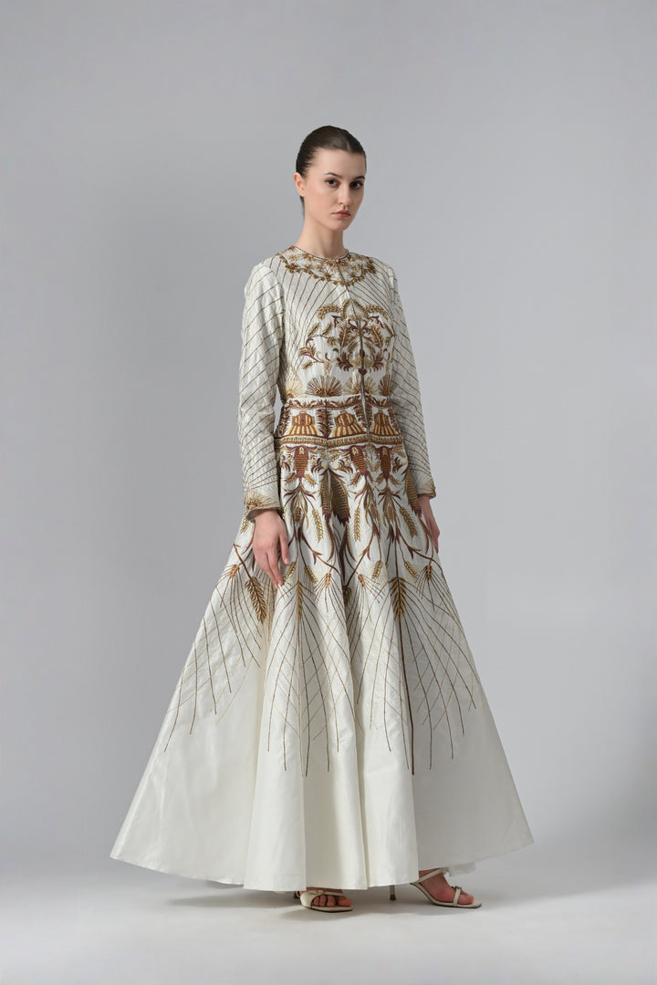 Ivory embroidered A-line gown featuring elegant round neckline, full-sleeves, structured bodice, and the gown is adorned with intricate botanical &amp; heritage-inspired motifs.
