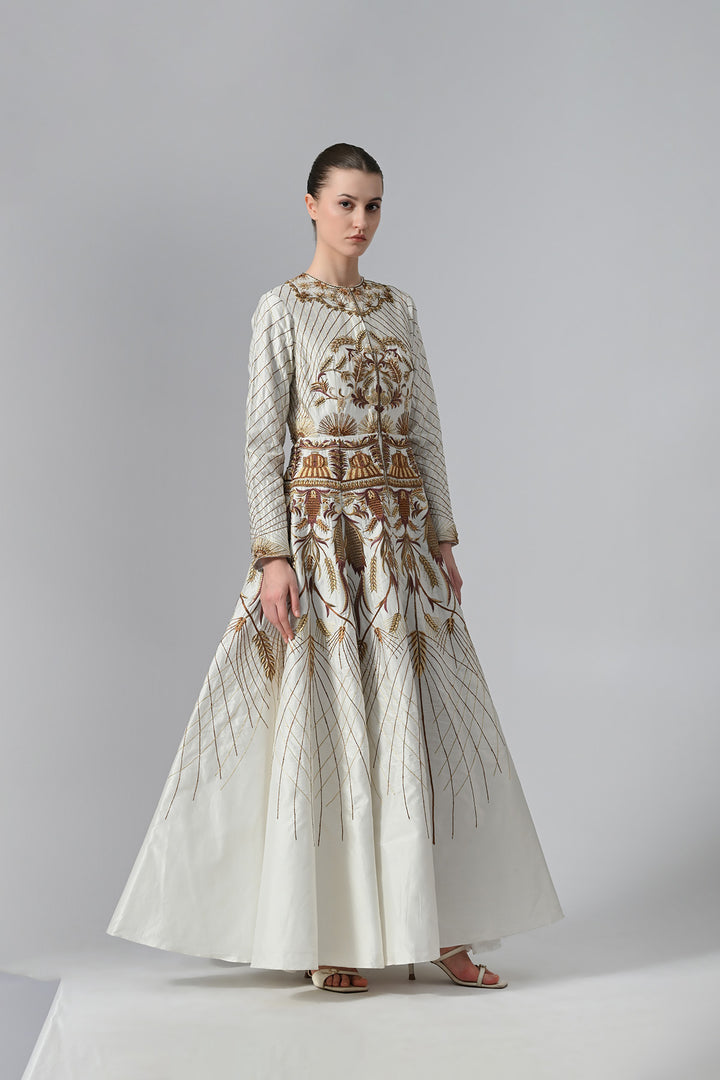 Ivory embroidered A-line gown featuring elegant round neckline, full-sleeves, structured bodice, and the gown is adorned with intricate botanical &amp; heritage-inspired motifs.