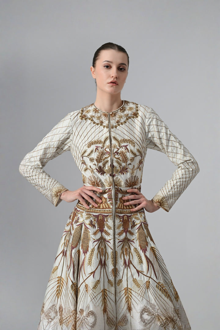 Ivory embroidered A-line gown featuring elegant round neckline, full-sleeves, structured bodice, and the gown is adorned with intricate botanical &amp; heritage-inspired motifs.