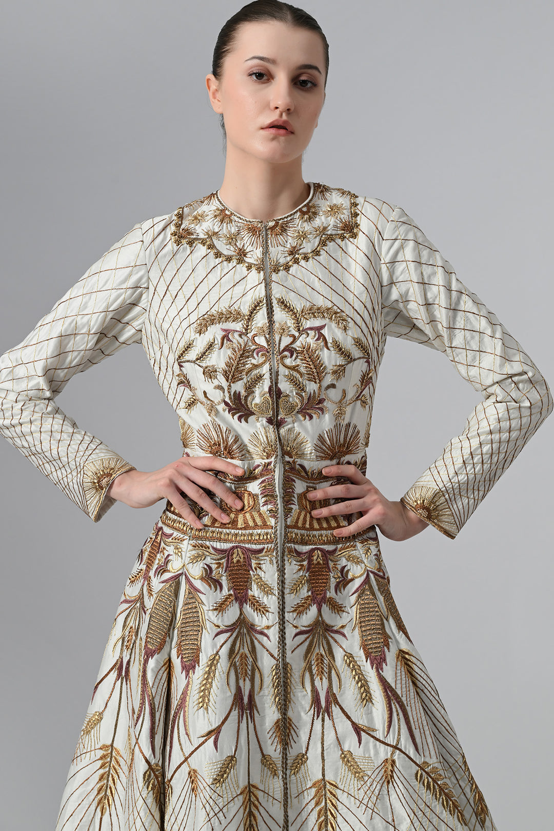 Ivory embroidered A-line gown featuring elegant round neckline, full-sleeves, structured bodice, and the gown is adorned with intricate botanical &amp; heritage-inspired motifs.