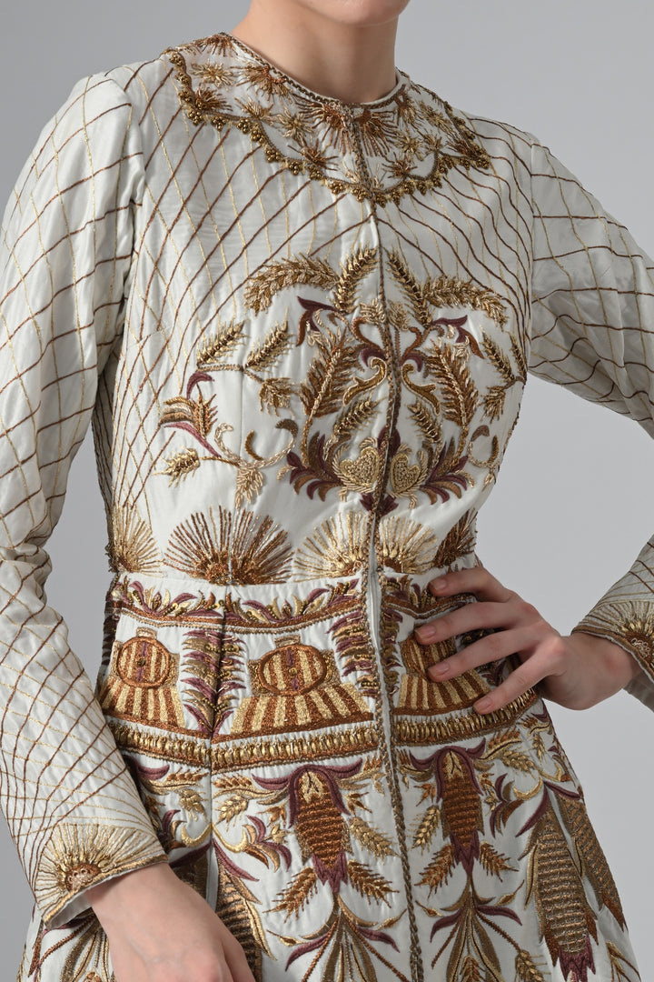 Ivory embroidered A-line gown featuring elegant round neckline, full-sleeves, structured bodice, and the gown is adorned with intricate botanical &amp; heritage-inspired motifs.