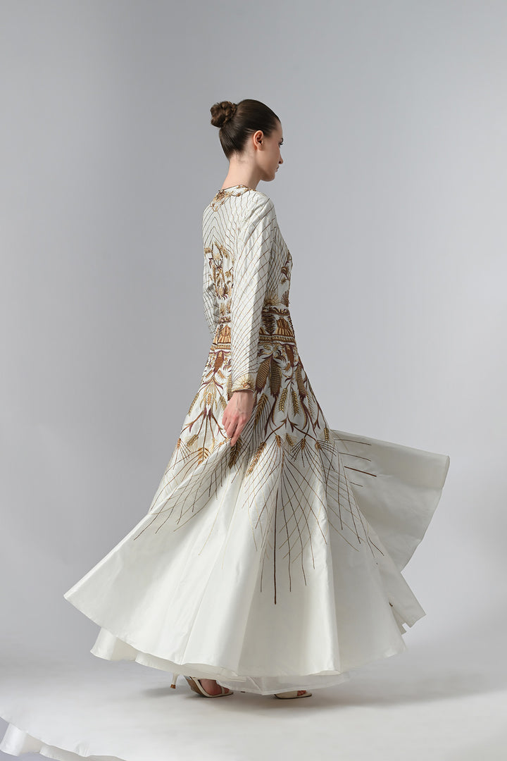 Ivory embroidered A-line gown featuring elegant round neckline, full-sleeves, structured bodice, and the gown is adorned with intricate botanical &amp; heritage-inspired motifs.