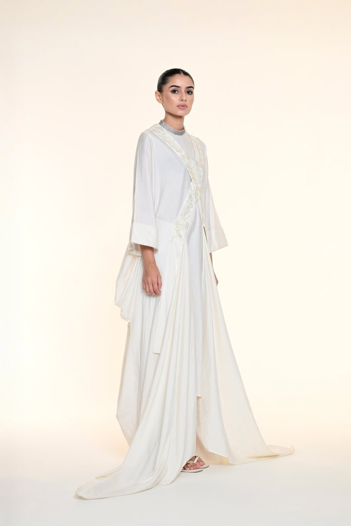 Ivory draped overlay dress with tonal floral embroidery, cascading panels, and relaxed statement sleeves.
