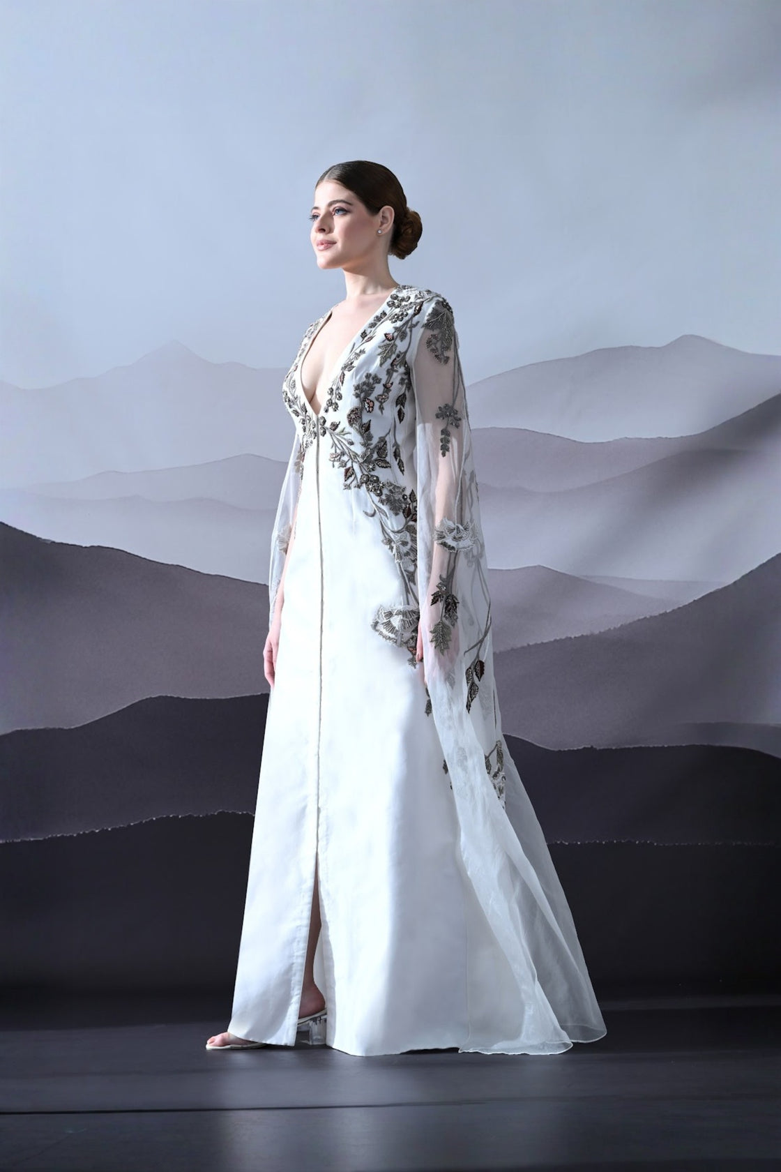 Ivory Gown With Hand-Embroidered Motifs And Sheer Cape Sleeves