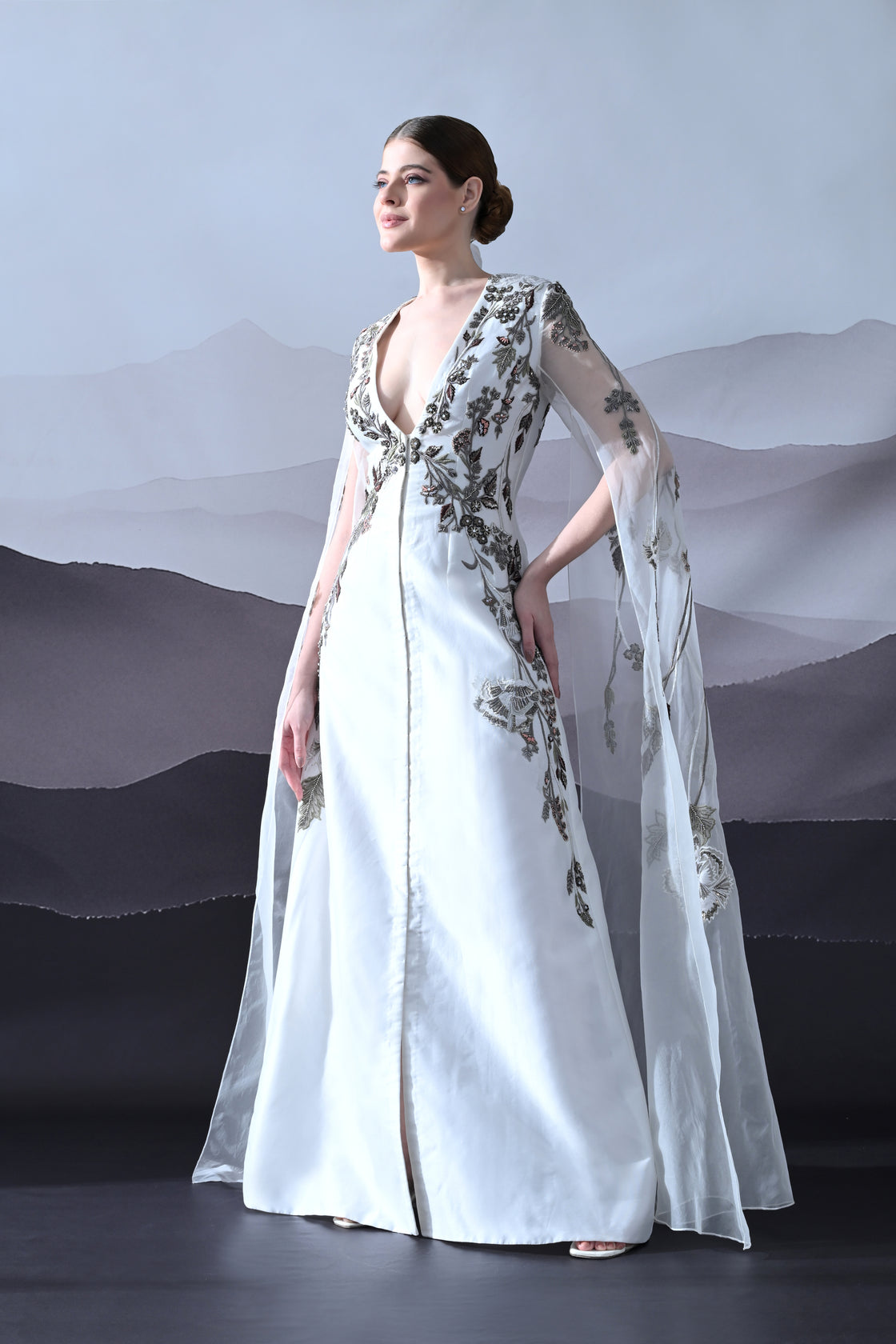 Ivory Gown with Hand-Embroidered Motifs and Sheer Cape Sleeves
