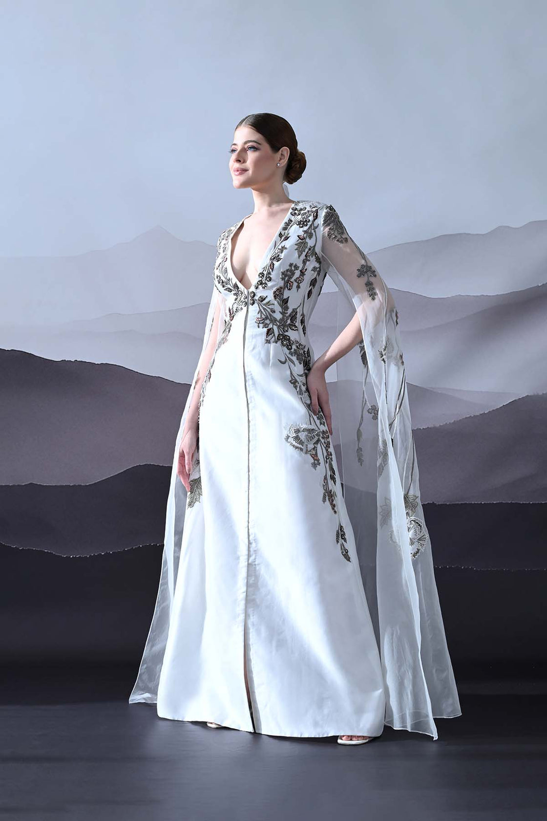 Ivory Gown With Hand-Embroidered Motifs And Sheer Cape Sleeves