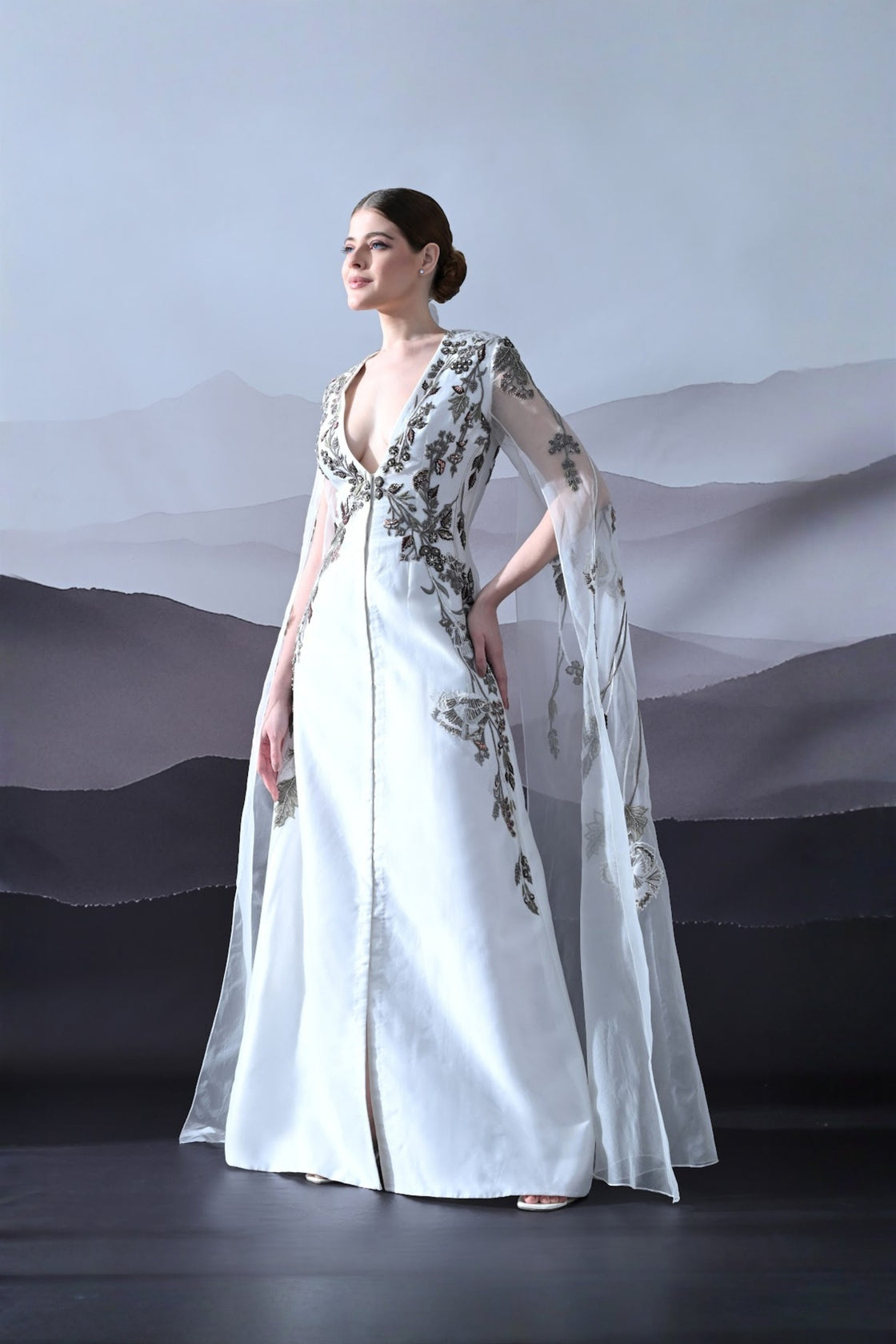 Ivory Gown With Hand-Embroidered Motifs And Sheer Cape Sleeves