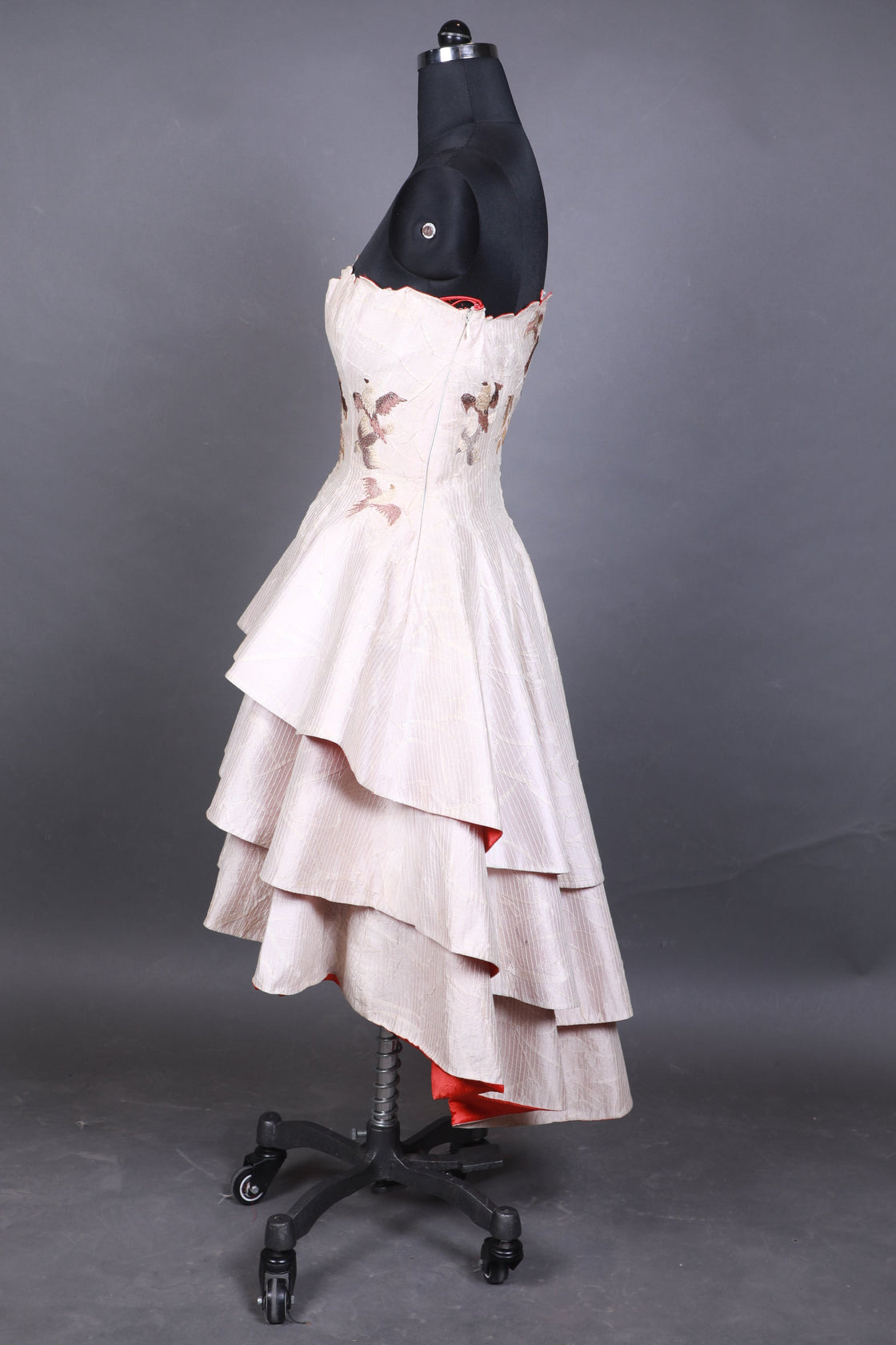 White bird-like sculpture with black accents on a gray background