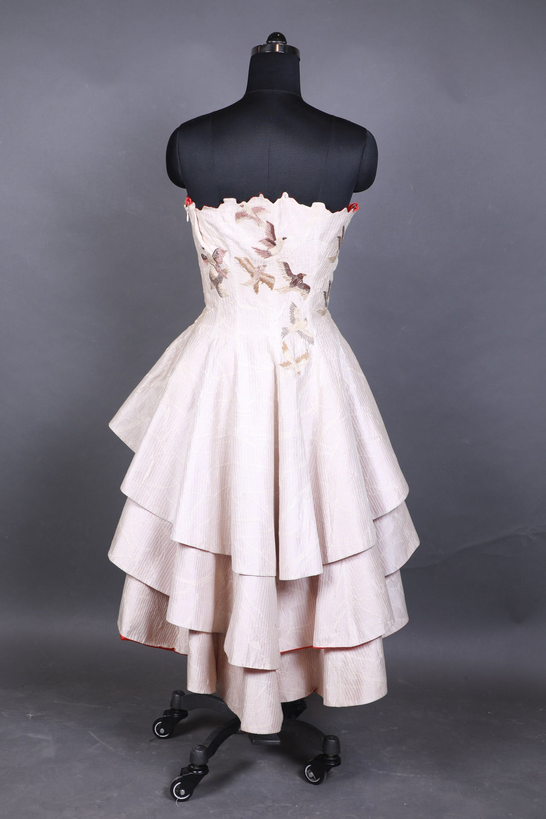 White dress on a black mannequin against a gray background