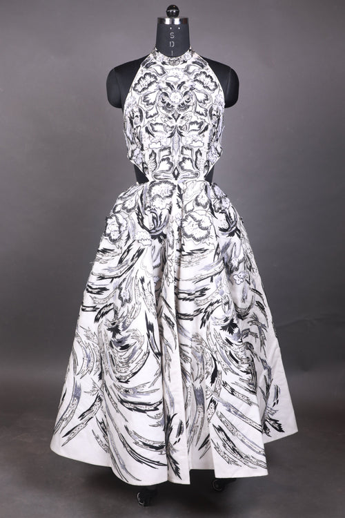 White dress with black pattern on a mannequin against a dark background