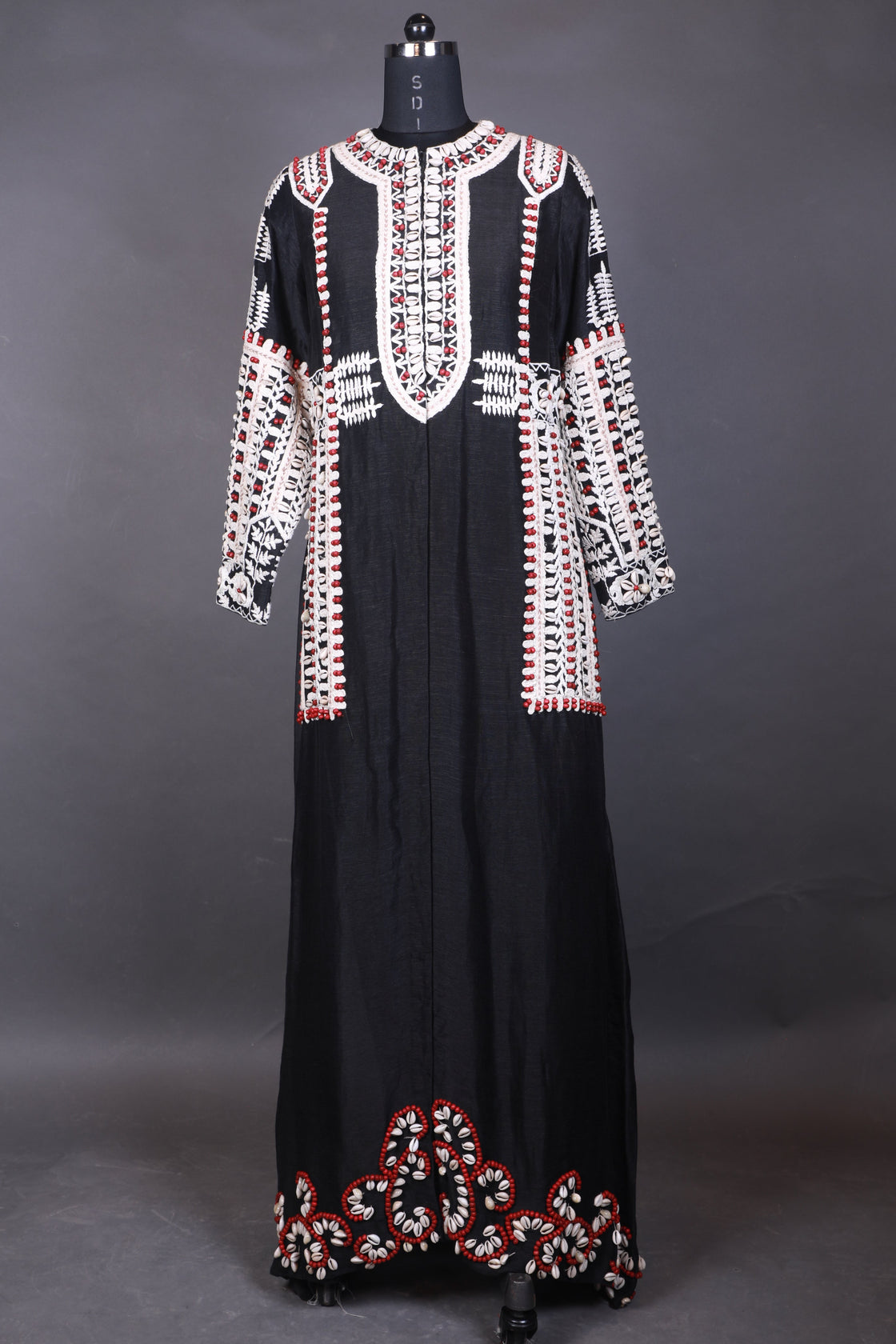 Black dress with red and white floral embroidery on a gray background