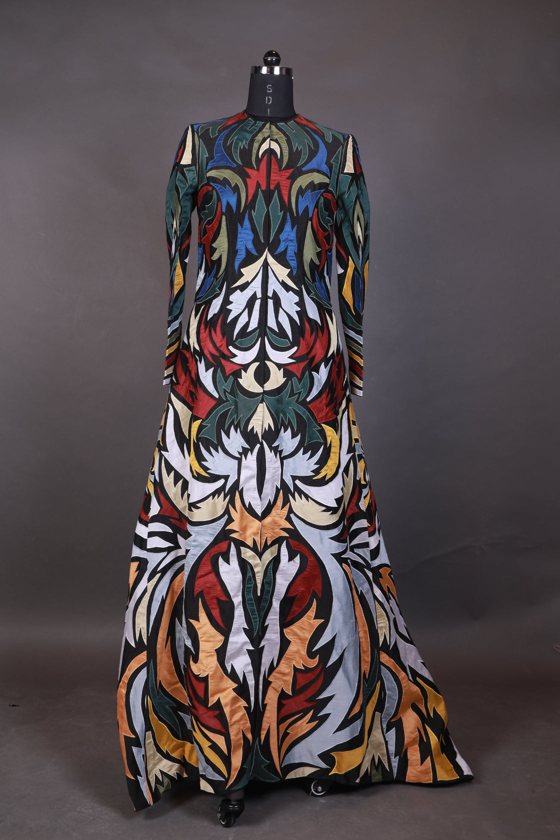 Hooded, floor length cotton silk gown, surfaced with colorful appliqué work all over.